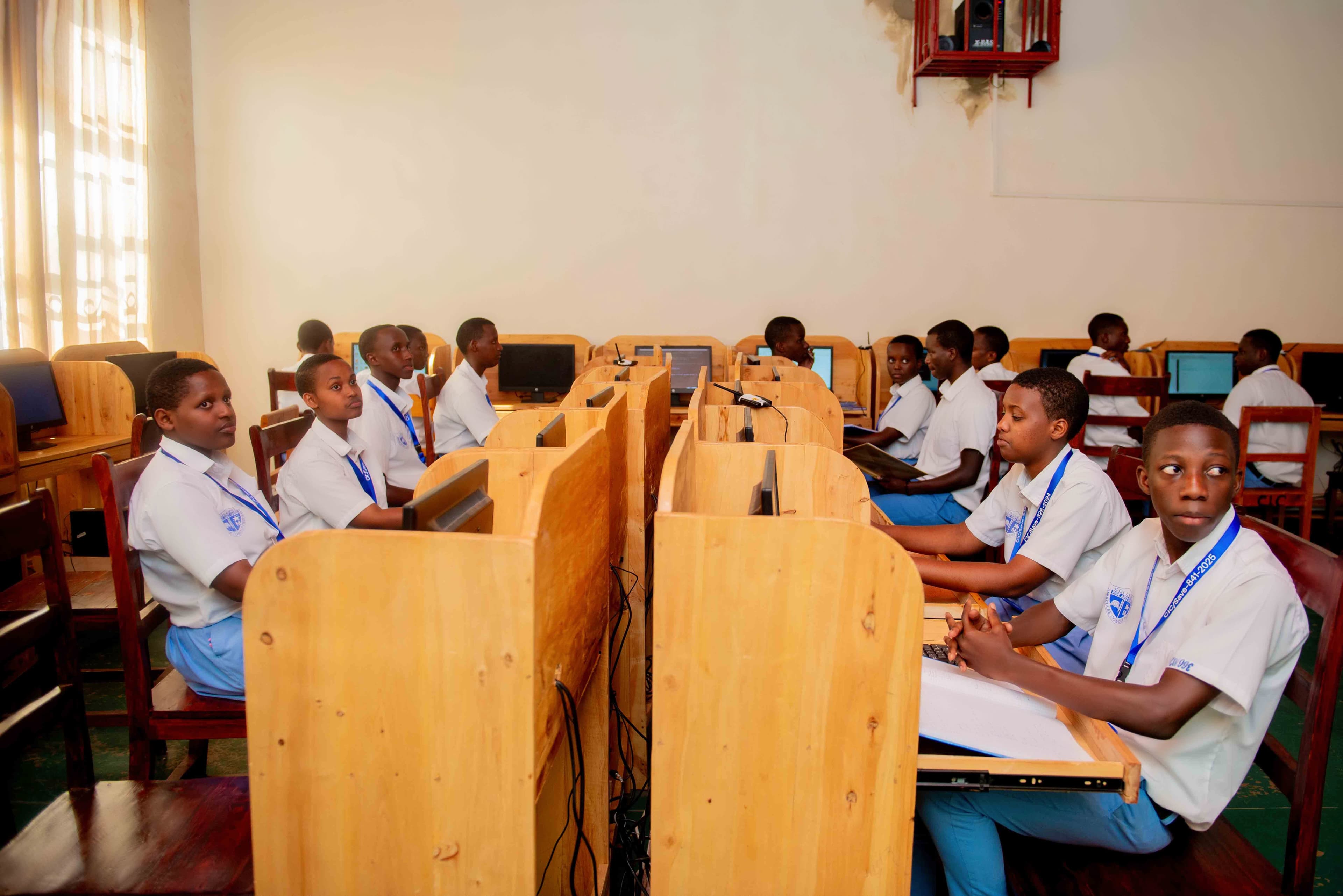 Students coding on computers or presenting tech projects on a smart board.
